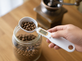 ScoopSense spoon scale scooping coffee beans from a jar
