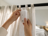 Clipping the GlideGlow curtain robot onto a curtain rod